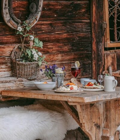 Ein Bild von einem schön gedeckten Holzbank mit einer leckeren Brotzeit der Seidlalm.