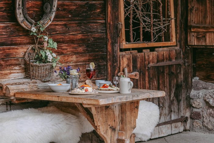 Ein Bild von einem schön gedeckten Holzbank mit einer leckeren Brotzeit der Seidlalm.