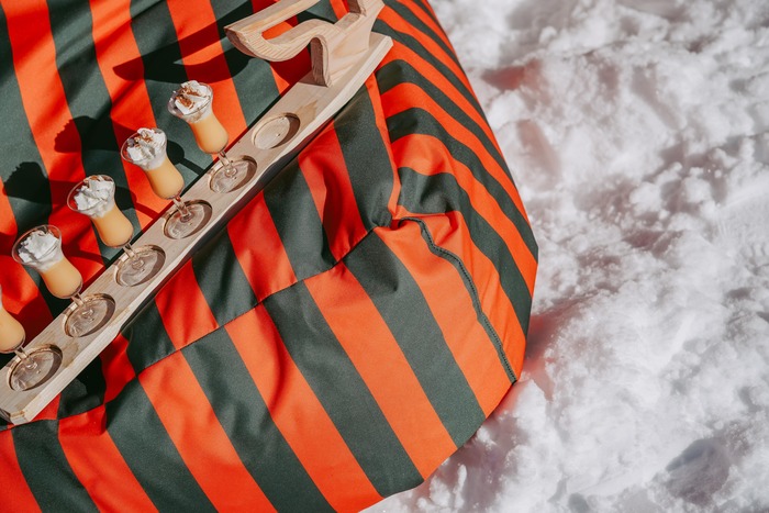 Bild von einem kleinen Tablett mit mehreren Getränken, platziert auf einem gestreiften Schilala Sitzsack.