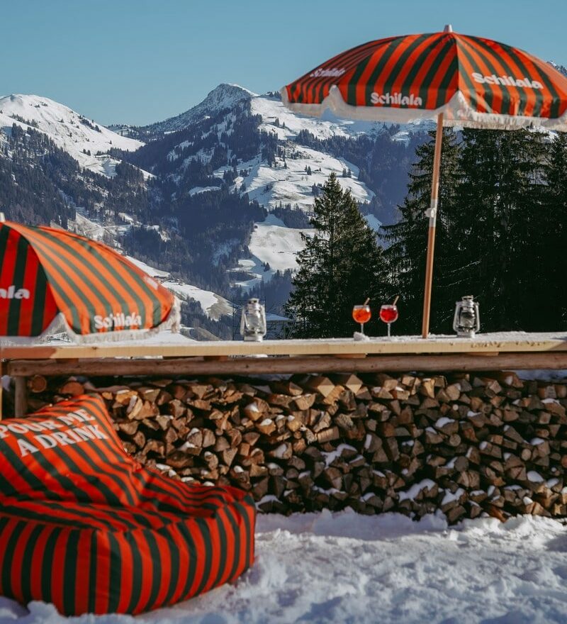 Panaroma Blick auf die verschneiten Kitzbühel Berge, Schilala Schirm und Sitzsack.