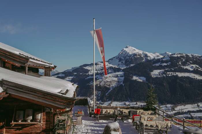 Panorama Blick von der Seidlalm Terasse auf die verschneiten Berge.