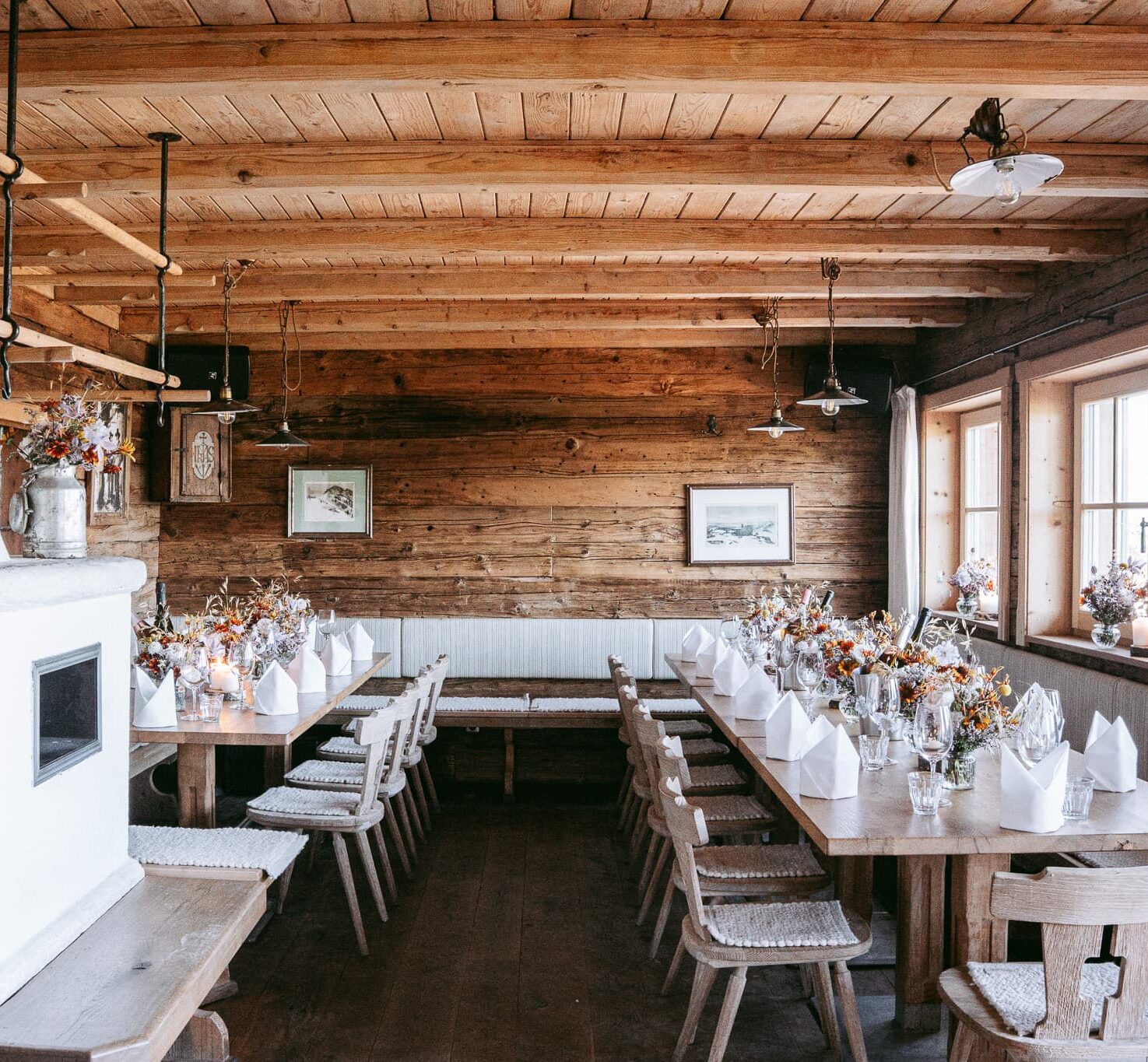 Seidlalm Events auf der Schilala Aprés Ski Hütte - Terasse mit Bänken und Tischen und Orange/ Grün gestreiften Schilala Kissen.